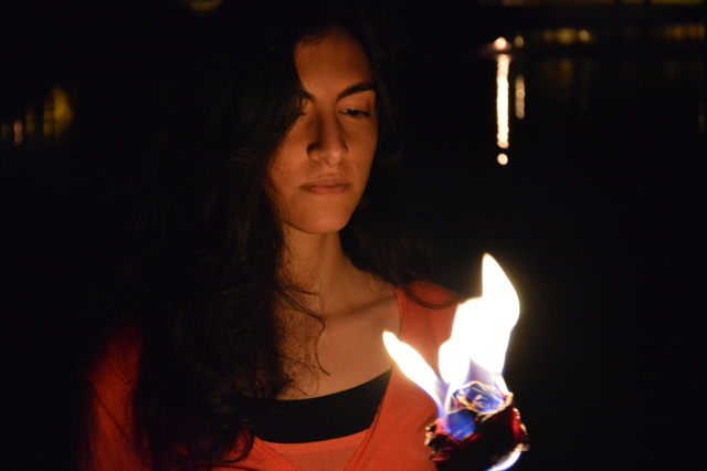 Maryam standing, holding a burning rose