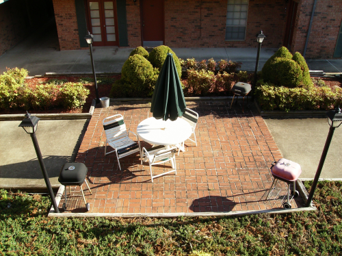 A square of bricks with grills and a patio table