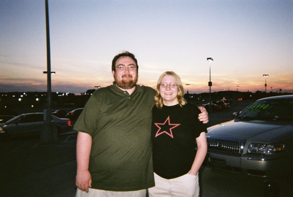 Doug and Sarah standing in a parkinglot together as sun sets